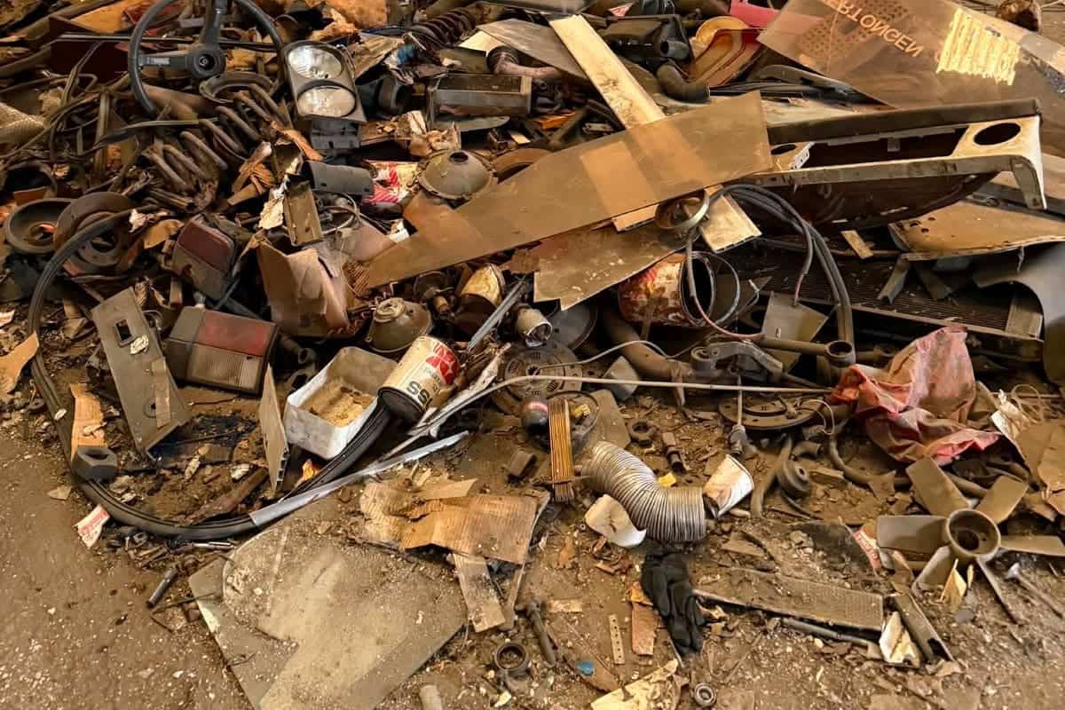 Grote hoop oud metaal, buizen en hout die als grof vuil wordt afgevoerd