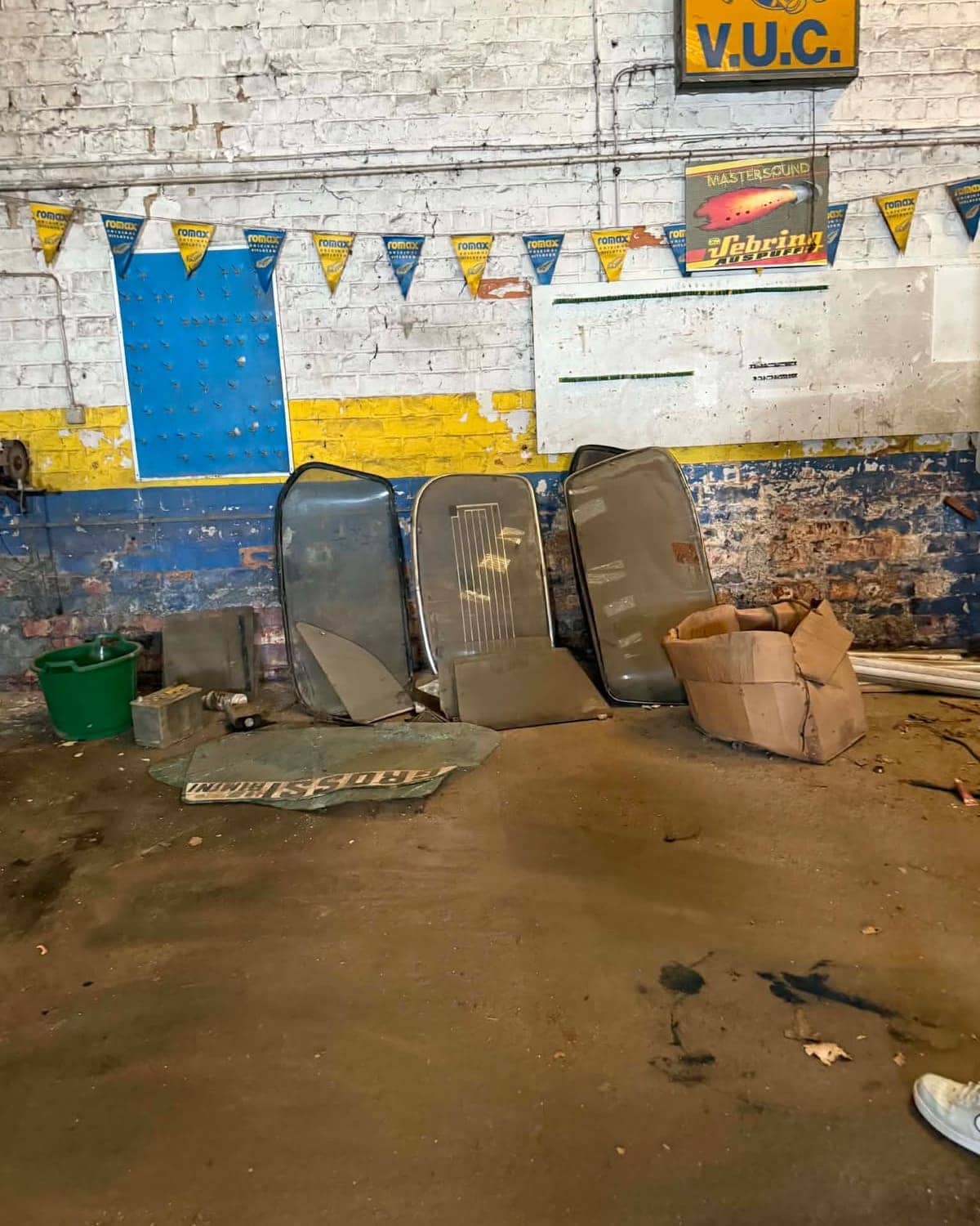 Dezelfde hoek van de loods leeg, met alleen nog wat plaatmateriaal tegen de muur